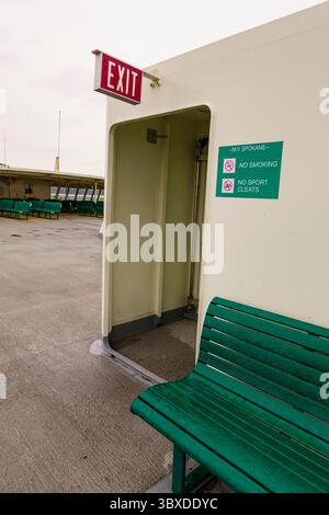 Exit sign and bench on deck of the Puget Sound ferry between Edmonds and Kingston Stock Photo