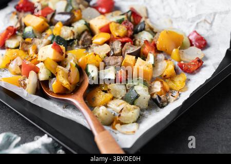Roasted vegetables on a baking tray on black background Stock Photo