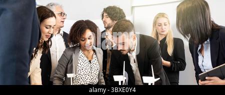 Diverse group of business professionals collaborating on wind energy models in office meeting. Multicultural team working on sustainability and innova Stock Photo