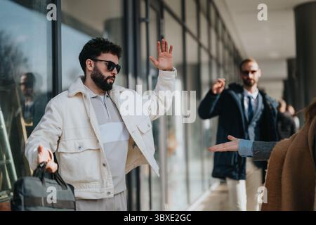 Two stylish men greeting each other outdoors on a sunny day Stock Photo