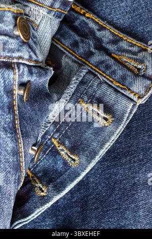 Inside of blue denim trousers sewn with orange threads, selective focus, close up Stock Photo