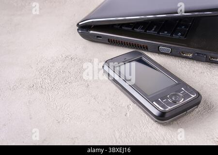 Laptop, smartphone lie on the table, place for text Stock Photo