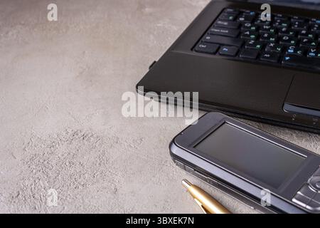 Laptop, smartphone, pen lie on the table, space for text Stock Photo