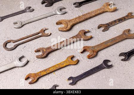 Old rusty tools lie on gray plaster, pattern Stock Photo