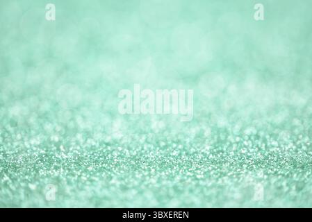 Texture of light green silver glitter dust surface, luxury background with bokeh Stock Photo