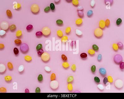 Many scattered colorful sweets, candies, lollipops on a pink background Stock Photo