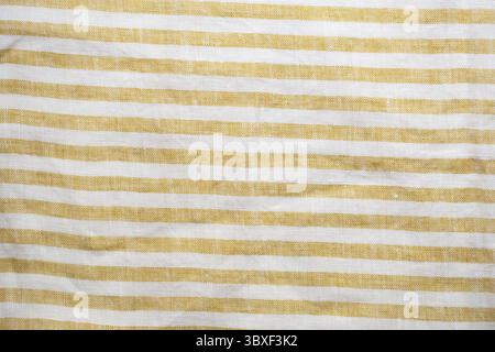 Yellow and white striped fabric with a rustic, woven texture. A seamless, natural pattern ideal for backgrounds, textiles, or decorative designs Stock Photo
