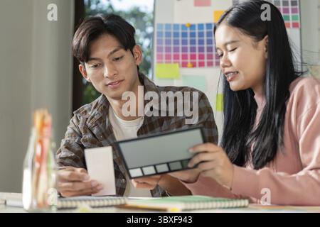 A design team collaborates on graphics blending innovative ideas and visuals in a vibrant workspace Stock Photo