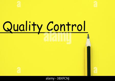 Quality control text written on yellow paper background Stock Photo
