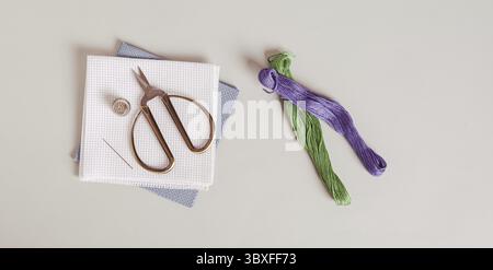 Food, Canvas, threads and cross stitch tools on gray background top view web banner Stock Photo