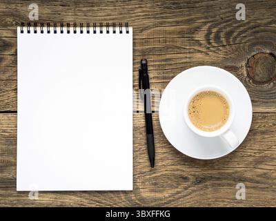 Open notepad with spiral, pen and coffee cup on old wooden table, top view Stock Photo