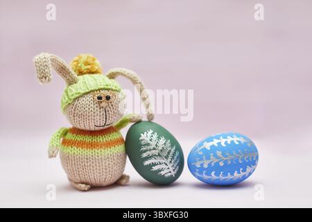 Knitted rabbit and two Easter eggs for a postcard Stock Photo