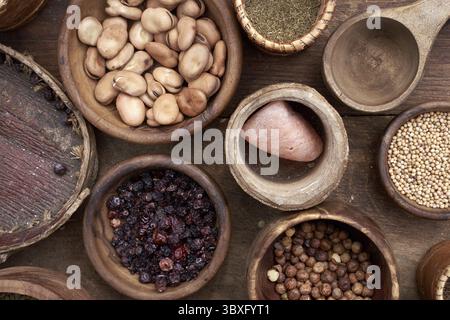 Medieval food in wooden and ceramic dinnerware. Cereals, seeds, dried berries, beans, salt and other foods Stock Photo