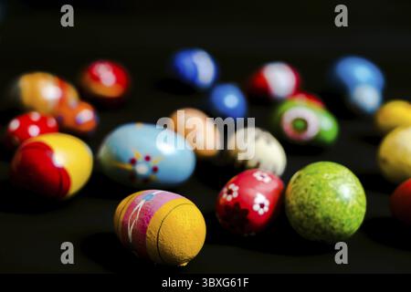 Multicolored wooden eggs on black background Stock Photo