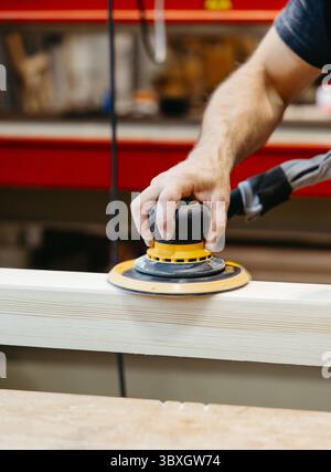 Detailed view of electric sanding work on wood in a carpentry workshop Stock Photo