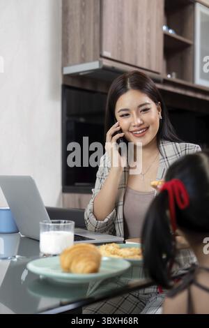 Working mom work from home office. businesswoman and cute child using laptop work freelancer workplace in home, Lifestyle family moment Stock Photo