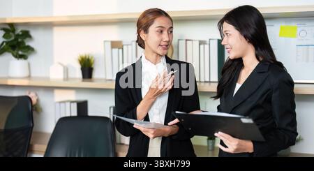 Effective Communication. Two women discussing business strategies in a modern office setting. Stock Photo