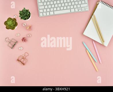 Top view of modern pink woman office desktop with blank notepad, computer. Mock up, empty space Stock Photo