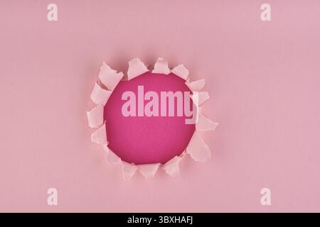 Pink textured background with wrapped hole in it, copy space top view Stock Photo
