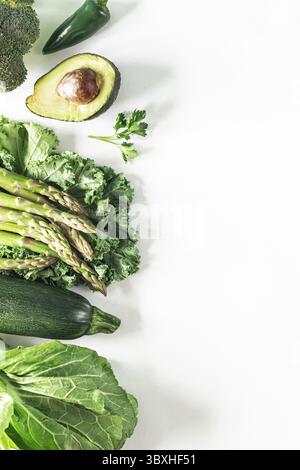 Food, Various fresh green vegetables on a white background: broccoli, celery, avocado, zucchini, kale, parsley, hot pepper, lettuce leaves. Healthy ve Stock Photo
