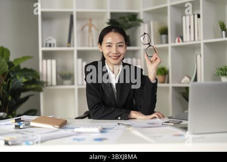 Young business woman asian or employee accounting bookkeeping documents checking financial data or marketing report working in office with laptop. Pap Stock Photo