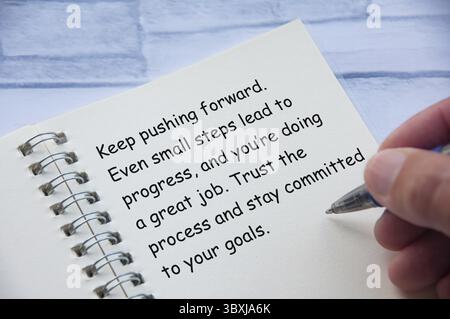Motivational and inspirational or encouragement quote relating to progress and challenges written on notepad. Inspirational and encouragement concept Stock Photo