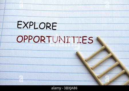 Explore Opportunities text on notebook with wooden ladder background Stock Photo