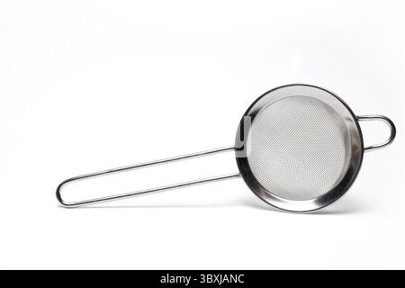 Close up of small silver metal strainer tea kitchen strainer isolated on white background Stock Photo