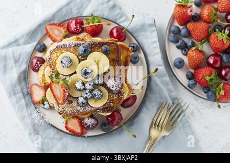 Healthy french toasts with berries and banana, confort stack of toasts, homemade brioche Stock Photo