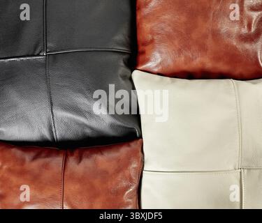 Closeup of view of handcrafted sofa cushions made from smooth genuine black, brown and cream leather with neat decorative stitching. Stylish soft inte Stock Photo