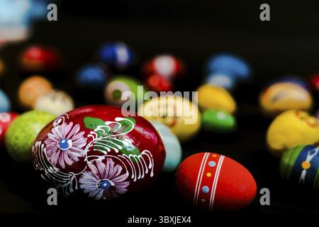 Multicolored wooden eggs on black background Stock Photo