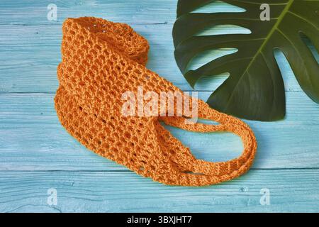 Orange string bag on a blue wooden background Stock Photo