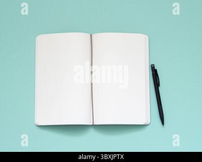 Top view of blank note paper with pen on aqua table background Stock Photo