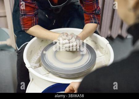 Woman making ceramic pottery on wheel, hands closeup. Concept for woman in freelance, business, creative hobby. Earn extra money, side hustle Stock Photo