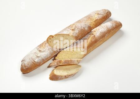 Two whole and sliced fresh French baguettes with golden crust and airy texture, isolated on white background. Traditional bakery products concept Stock Photo