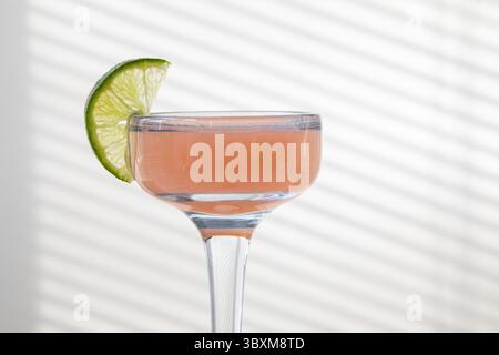cocktail glass of pink grapefruit juice and a slice of lime. Stock Photo