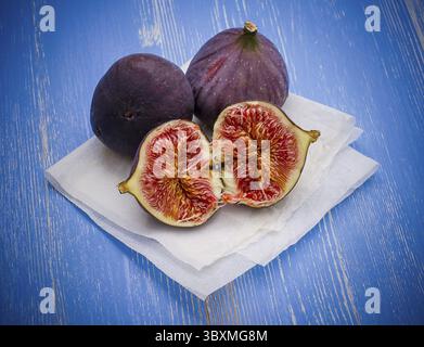 Three ripe figs on baking paper background, top view Stock Photo