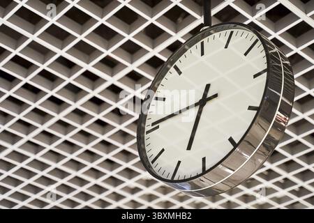 Modern clock with dial on structured wall background in black and white with chrome Stock Photo