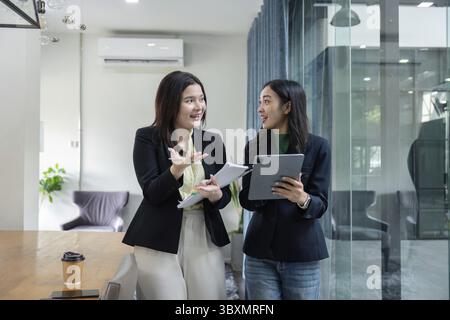 Two professionals engage in a lively discussion about financial strategies, highlighting teamwork and partnership Stock Photo