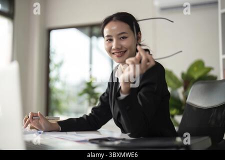 Young business woman asian or employee accounting bookkeeping documents checking financial data or marketing report working in office with laptop. Pap Stock Photo