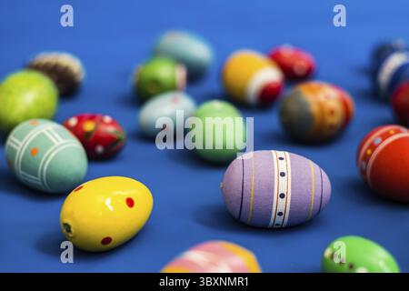 Multicolored wooden eggs on blue background Stock Photo