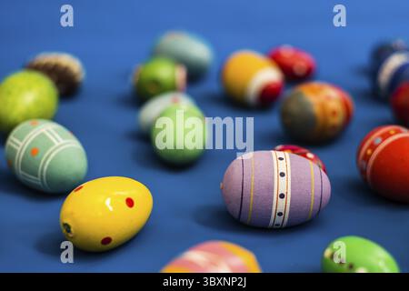 Multicolored wooden eggs on blue background Stock Photo