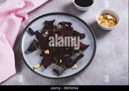 Food, Homemade beet chips with rosemary and garlic on a plate on the table Stock Photo