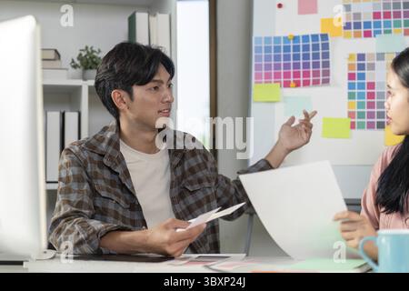 Creative design team discussing graphics strategy in modern office environment for enhanced collaboration Stock Photo