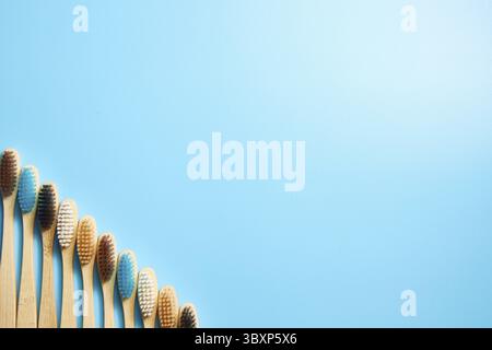 Multi-colored wooden toothbrushes. Place for text on a blue background Stock Photo
