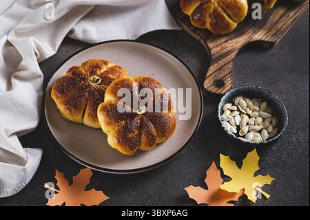 Food, Autumn pumpkin shaped bread buns sprinkled with sugar on a plate on a table Stock Photo