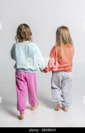 Colorful children's sweatshirts and trousers close-up. Vertical photo. Stock Photo