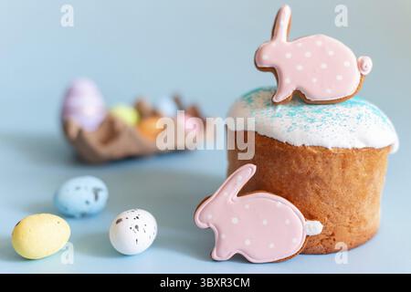 Easter still life with gingerbread in the form of a rabbit on an Easter cake, small decorative multicolored eggs lie next to it Stock Photo