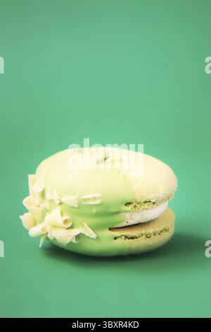 Green Cake macaron or macaroon on green background. colorful almond cookies. French macaroon cake close-up. Macaroons on colored background Stock Photo