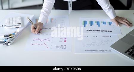 A business analyst examines sales charts and graphs, focusing on financial strategy and data analysis Stock Photo